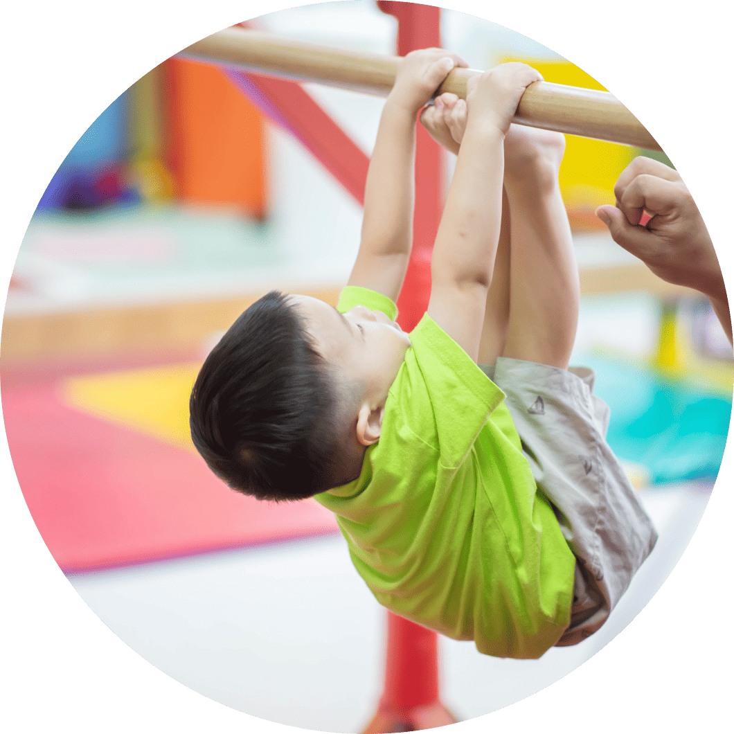 鉄棒に捕まっている男の子の写真