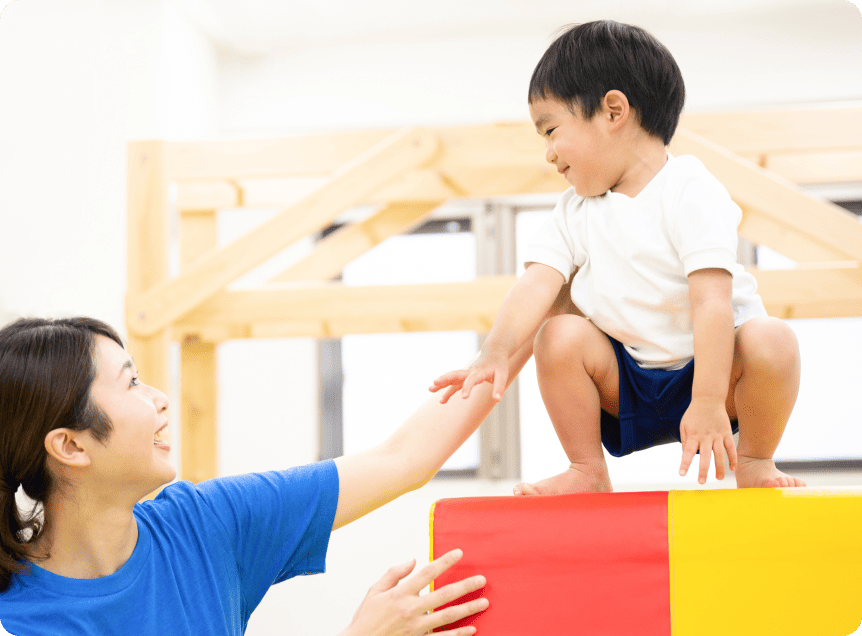 コーチにサポートしてもらっている男の子の写真