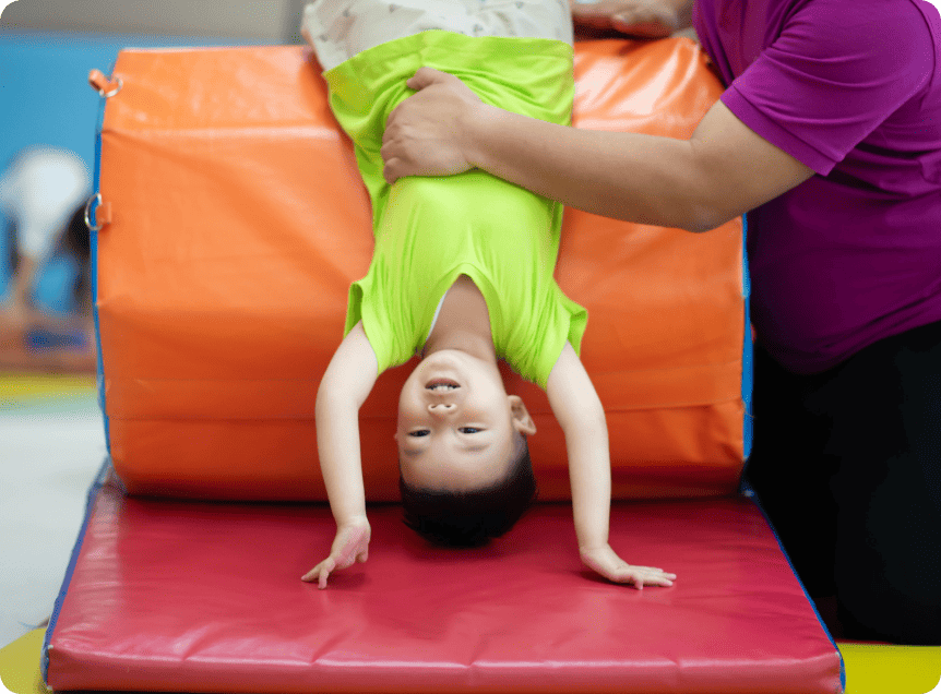 運動器具を使って、ブリッジをしている男の子の写真